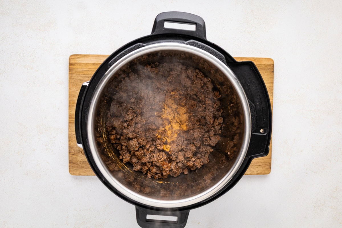 Seasonings added to the ground beef in the instant pot.