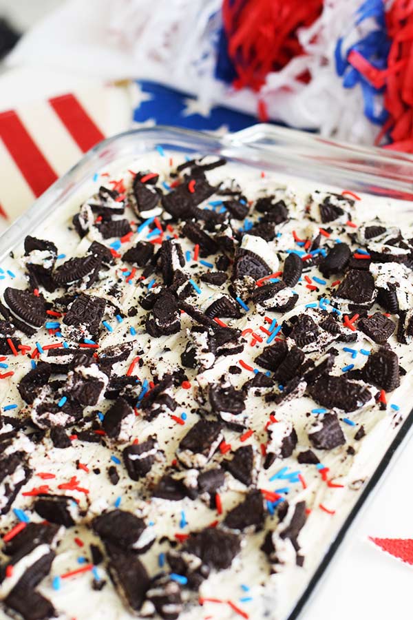 an overhead shot of these no bake fireworks oreo cheesecake bars with red, white, and blue sprinkles and chopped oreos on top