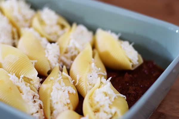 these cheesy stuffed jumbo shells in a baking dish over a bed of marinara sauce