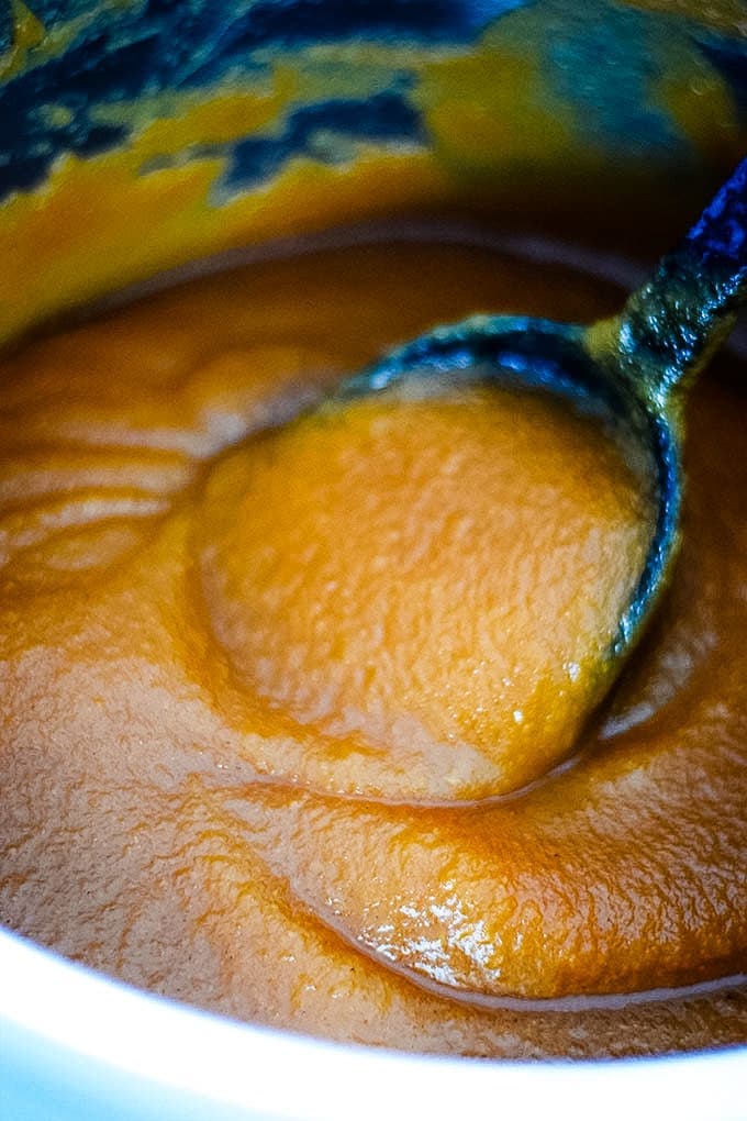 A closeup of this instant pot apple butter with a large black serving spoon