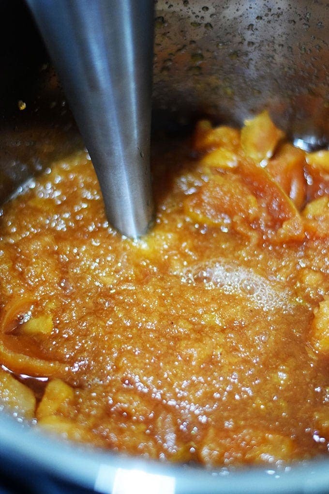 A closeup of this instant pot apple butter being blended with an immersion blender