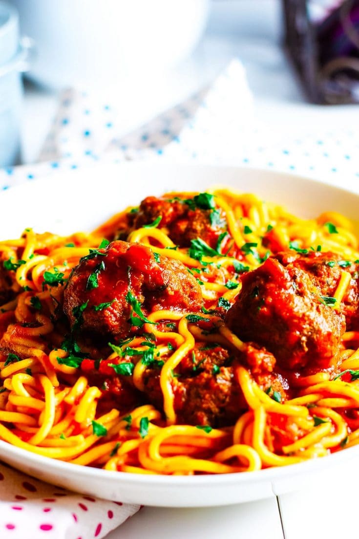 Instant Pot Spaghetti and Meatballs sprinkled with parsley nested in a white bowl 