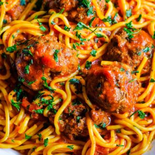 A close up of this Instant Pot spaghetti and meatballs with noodles, marinara sauce, and chopped basil