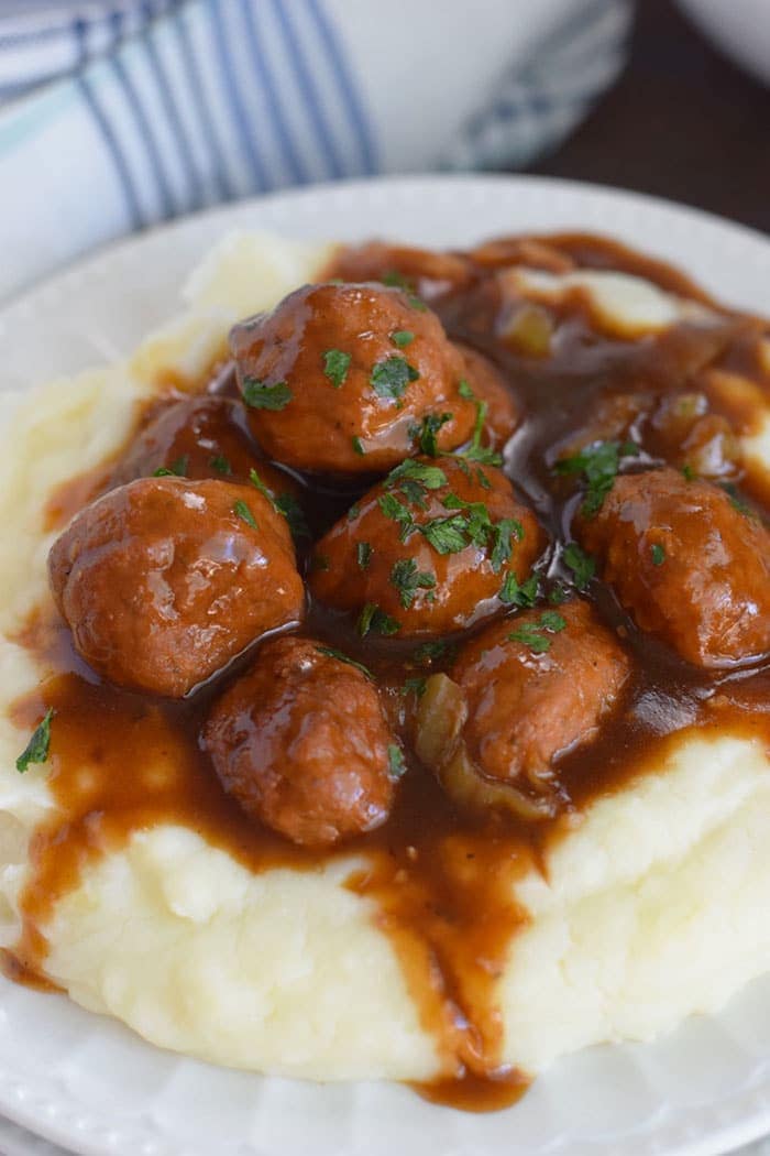 Instant Pot Meatballs and Gravy over Mashed Potatoes on a white plate