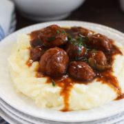 A white plate filled with mashed potatoes and these instant pot meatballs and gravy