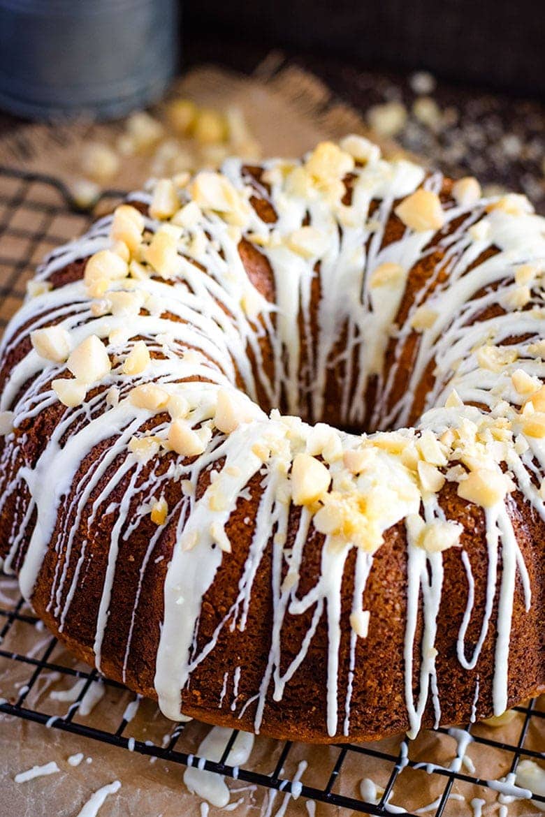 White Chocolate Macadamia Nut Pound Cake on Baking Rack with Icing and Nuts on Top