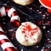 A closeup of this festive peppermint melt-away cookie with white chocolate icing and candy cane sprinkles for the holidays and Christmas