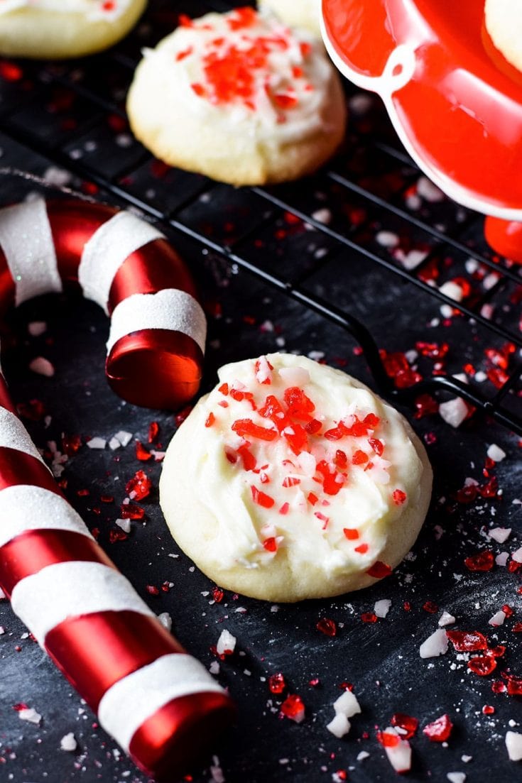 A closeup of this festive peppermint melt-away cookie with white chocolate icing and candy cane sprinkles for the holidays and Christmas