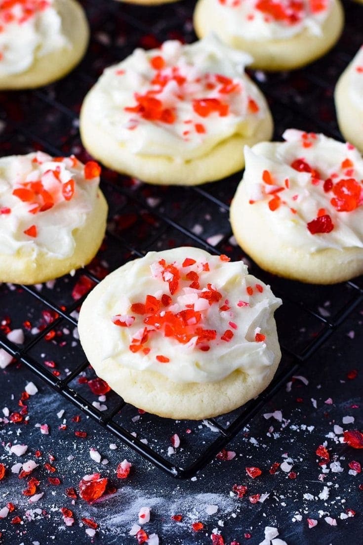 A closeup of this festive peppermint melt-away cookie with white chocolate icing and candy cane sprinkles for the holidays and Christmas