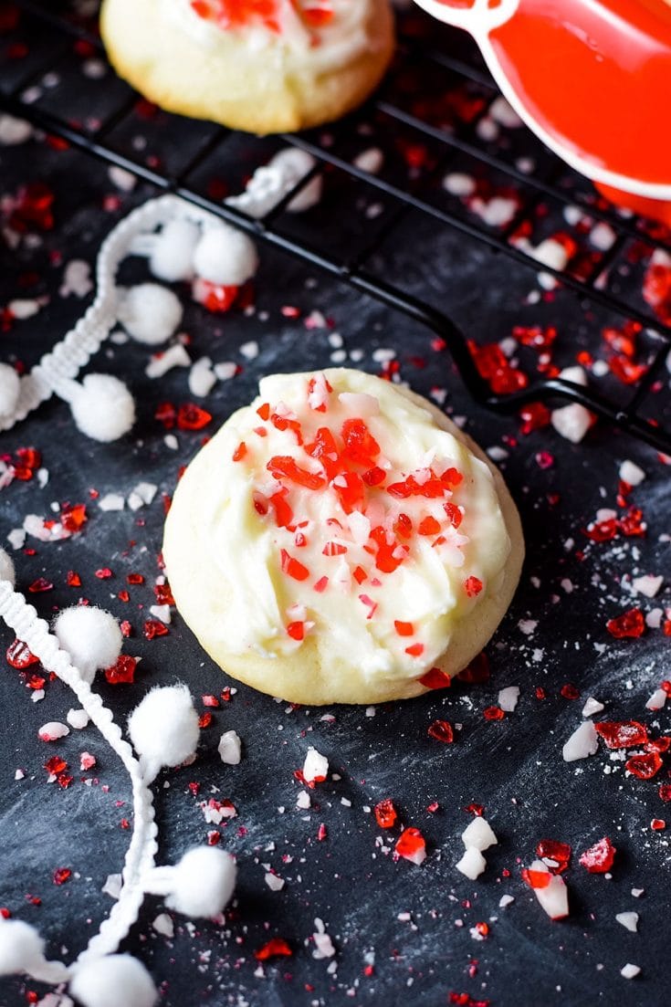 A closeup of this festive peppermint melt-away cookie with white chocolate icing and candy cane sprinkles for the holidays and Christmas