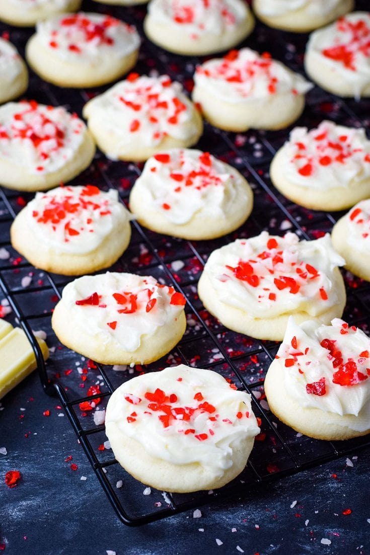 A closeup of these festive peppermint melt-away cookies with white chocolate icing and candy cane sprinkles for the holidays and Christmas