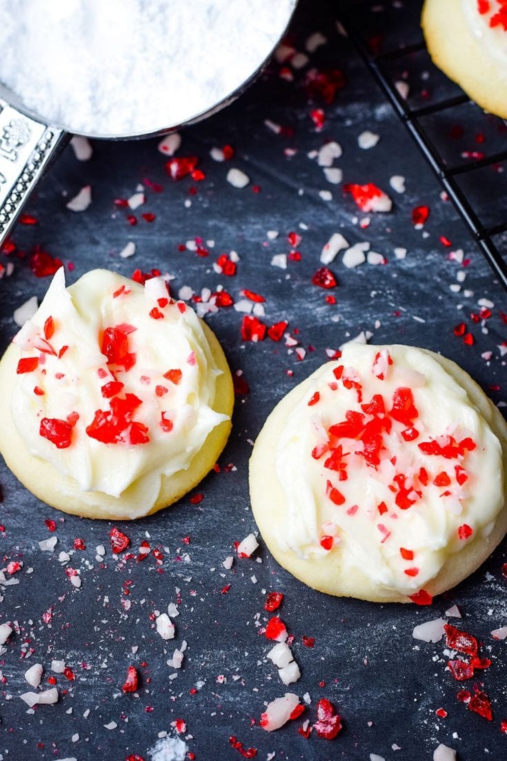 A closeup of these festive peppermint melt-away cookies with white chocolate icing and candy cane sprinkles for the holidays and Christmas