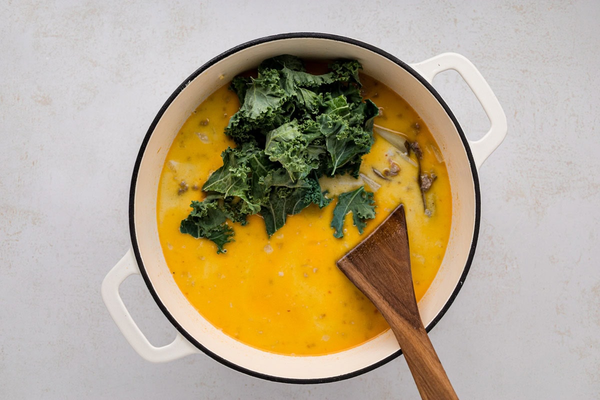 Kale added to the soup pot.