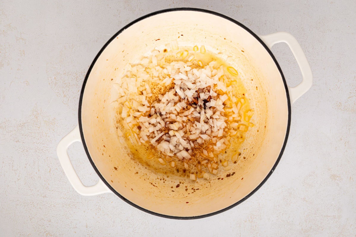 Onion added to grease in a dutch oven.