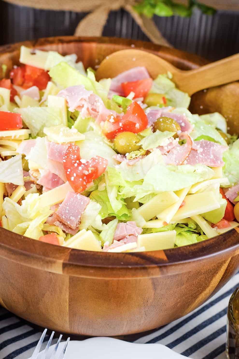 A close-up of a bowl of salad, with cheese and vinaigrette.