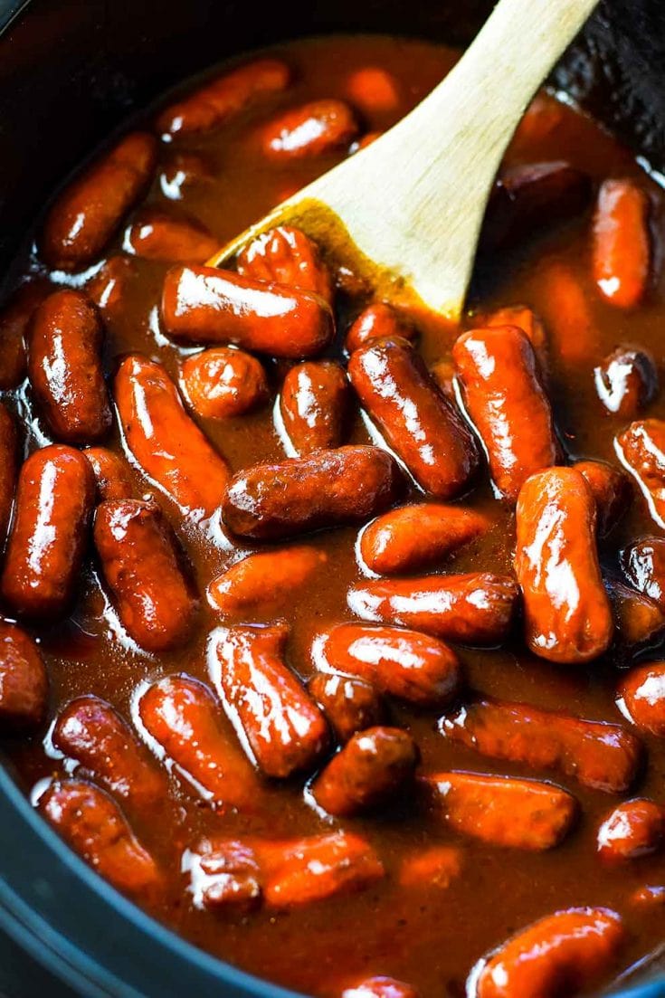 A slow cooker filled with these crock pot barbecue little smokies smothered in bbq sauce