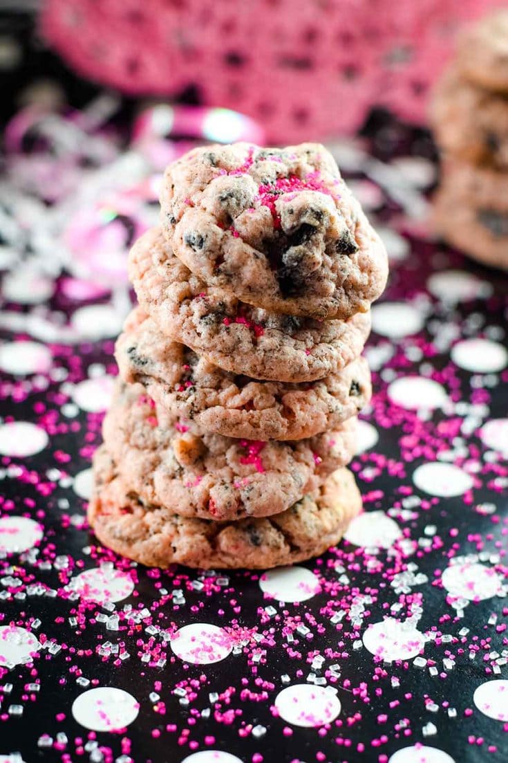 A festive stack of strawberry Oreo cheesecake cookies with pink confetti
