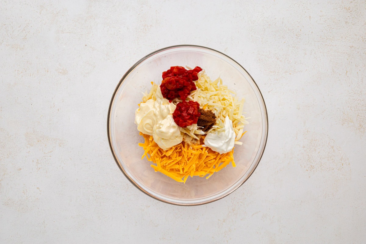 Ingredients for pimento cheese in a glass bowl.