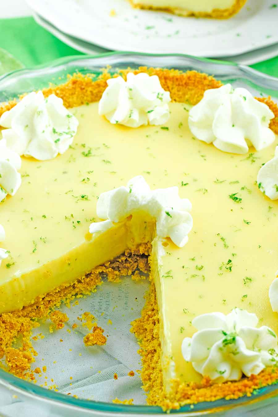 a pie dish with the best key lime pie recipe and one slice removed