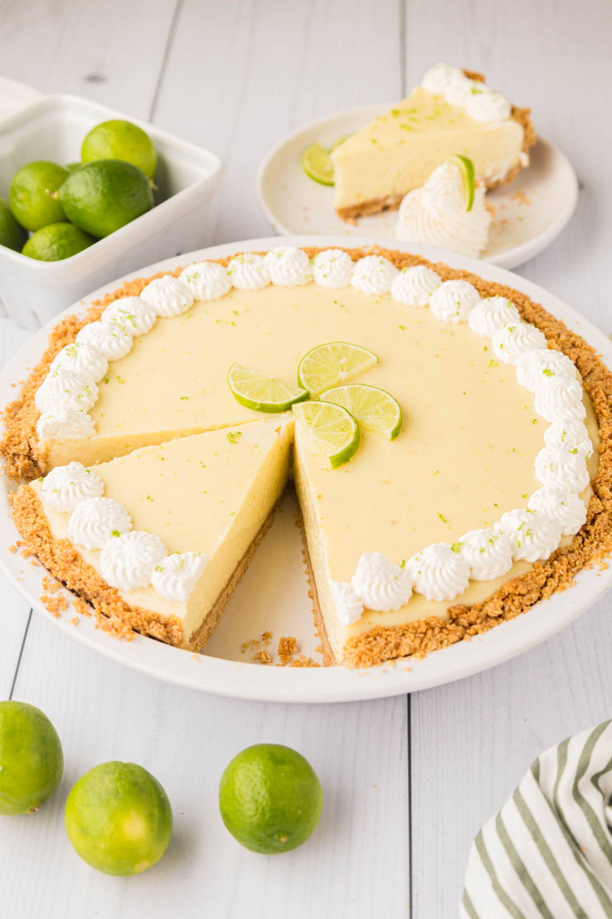 A whole key lime pie cut with a slice removed.