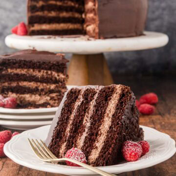 A slice of chocolate mousse layer cake on a white plate.