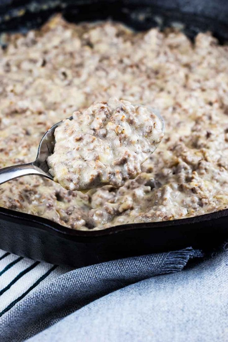 A close-up of a cast iron skillet filled with this Easy Creamed Hamburger Gravy recipe