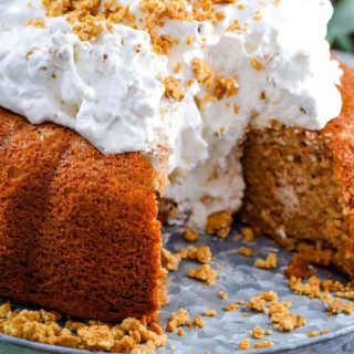 A side view of this easy carrot cake with whipped cream icing with two slices removed revealing the moist bundt cake center