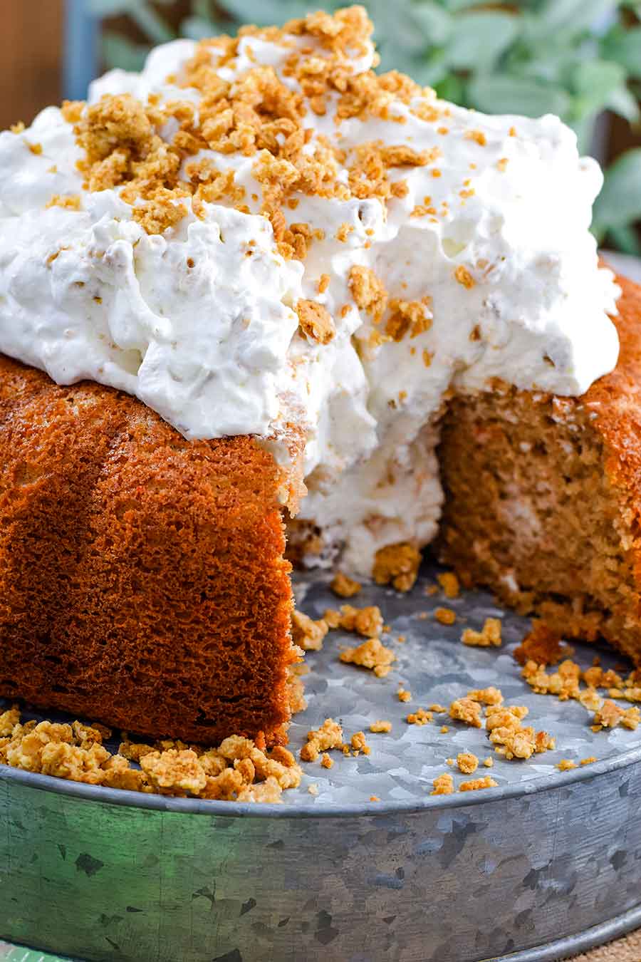 A side view of this easy carrot cake with whipped cream icing with two slices removed revealing the moist bundt cake center