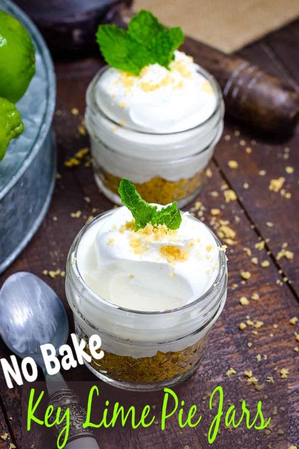 two small glass jars filled with this easy no-bake key lime pie in a jar recipe and garnished with fresh mint