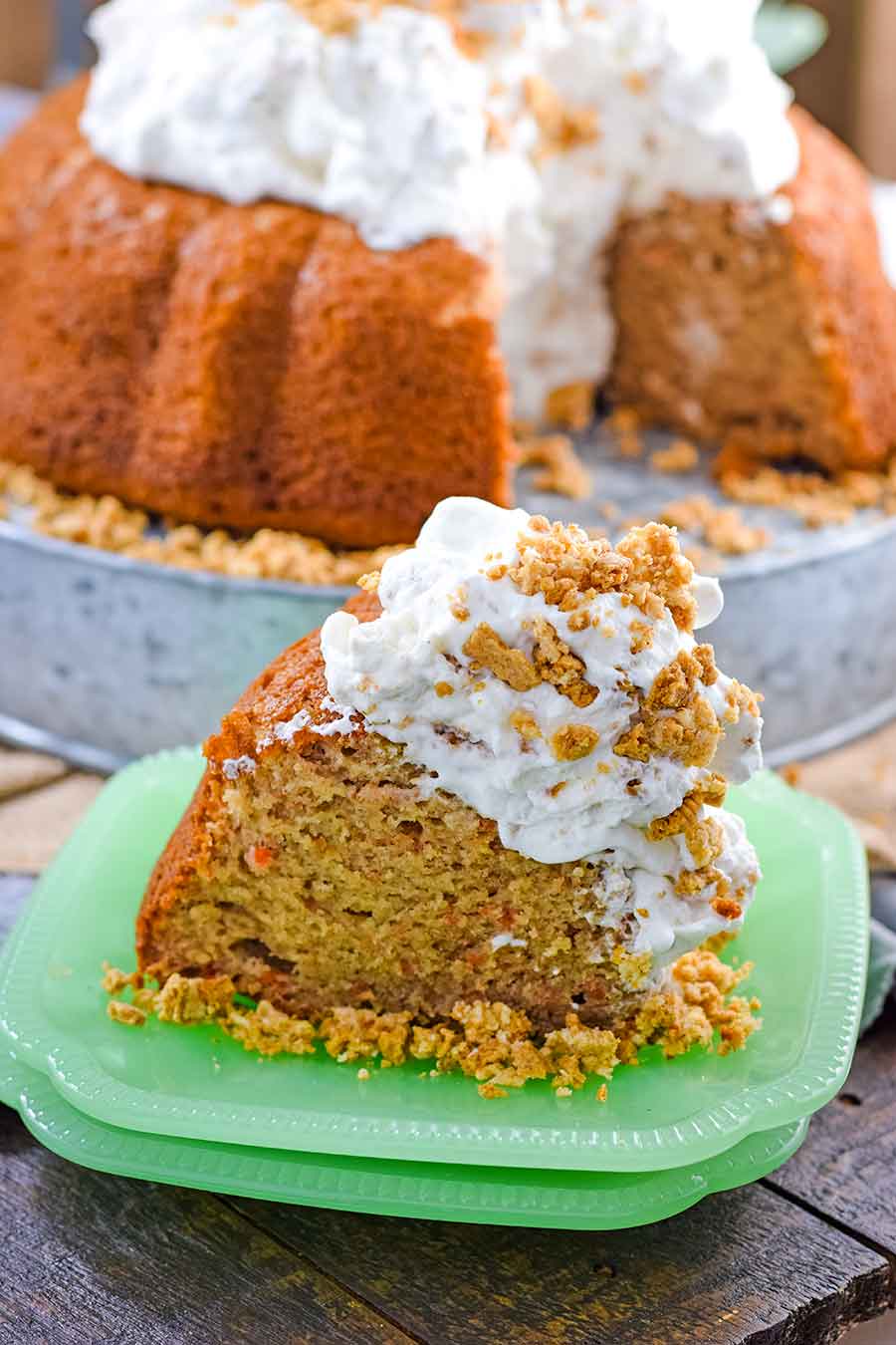 a slice of easy carrot cake with whipped cream icing on a green plate