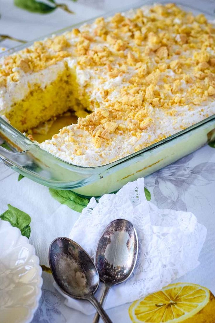 a casserole dish filled with lemon poke cake with one slice removed