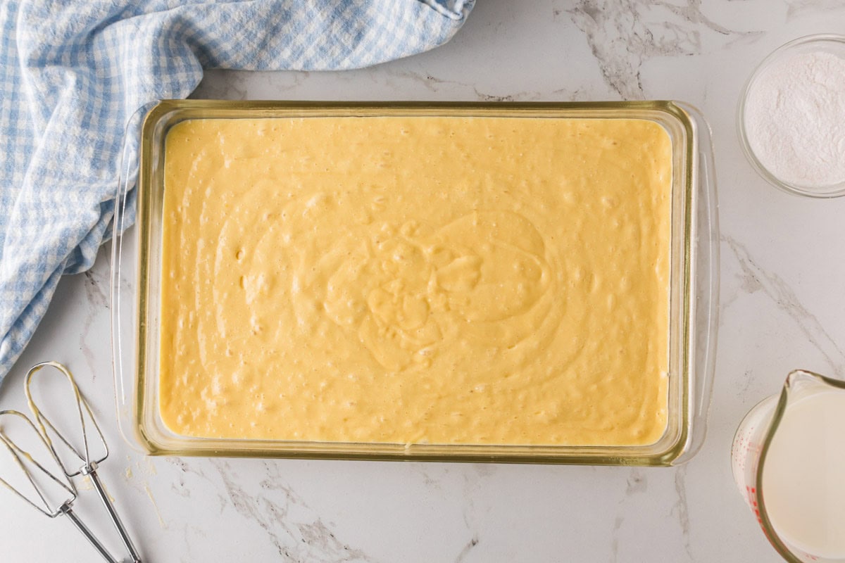 Lemon cake batter poured into a 9 x 13 baking dish.