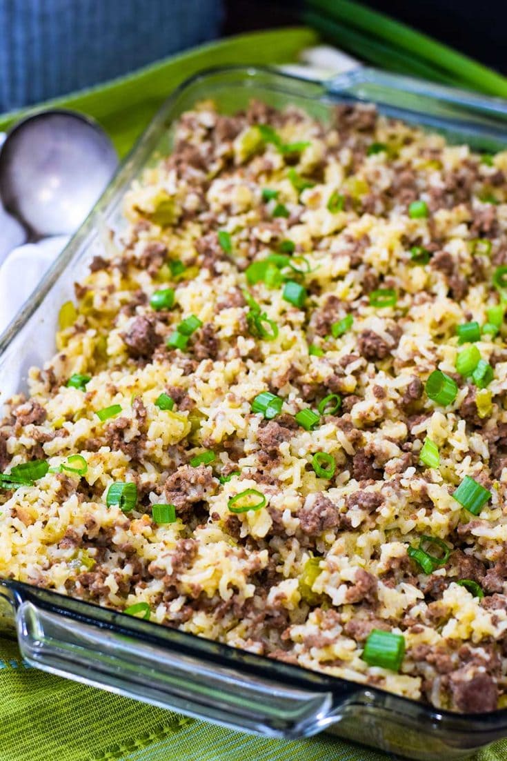 a casserole dish filled with ground beef and sausage casserole garnished with sliced green onions