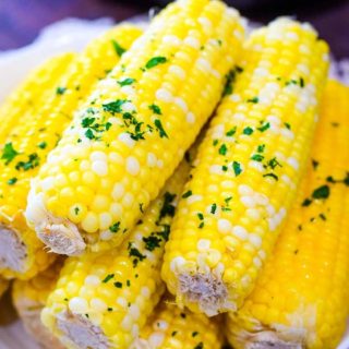 A plate of Instant Pot Corn on the Cob with chopped, fresh parsley