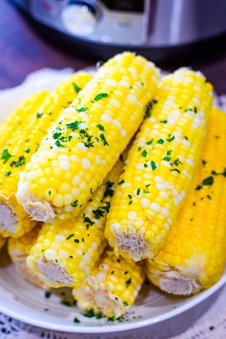 A plate of Instant Pot Corn on the Cob with chopped, fresh parsley