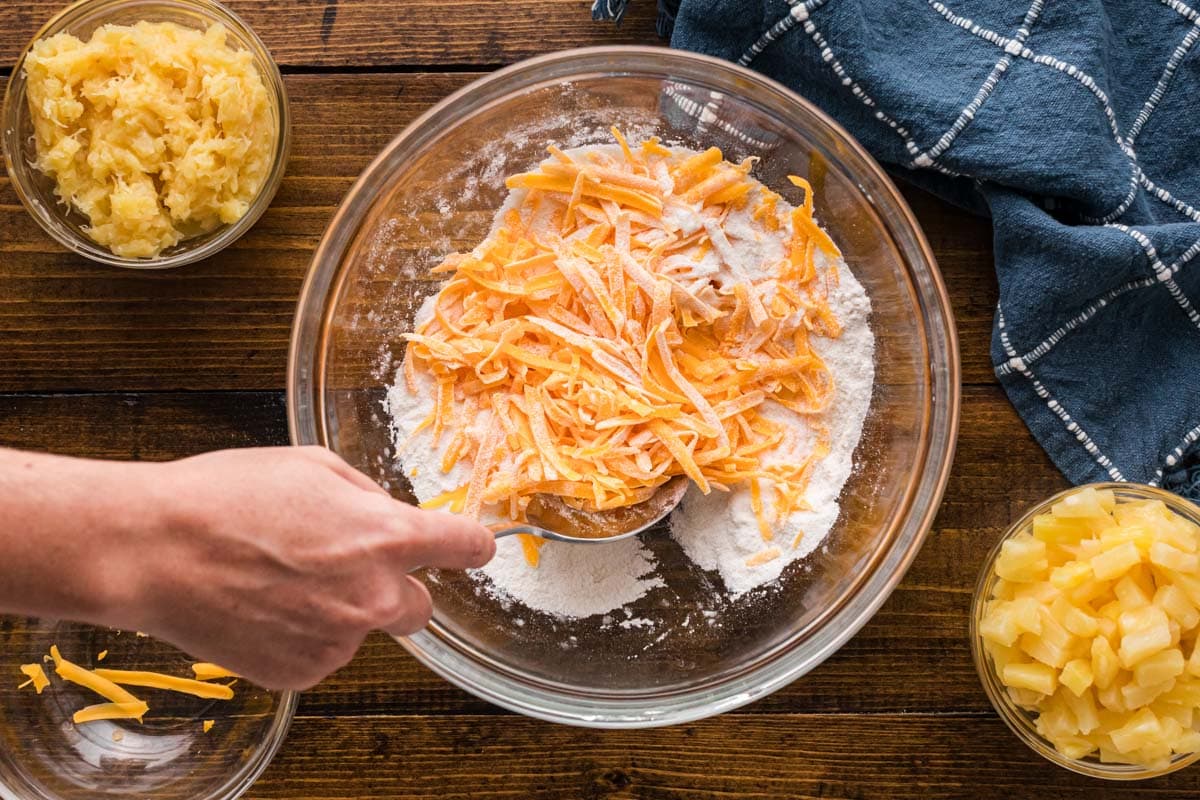 Adding cheese to flour and sugar mixture.