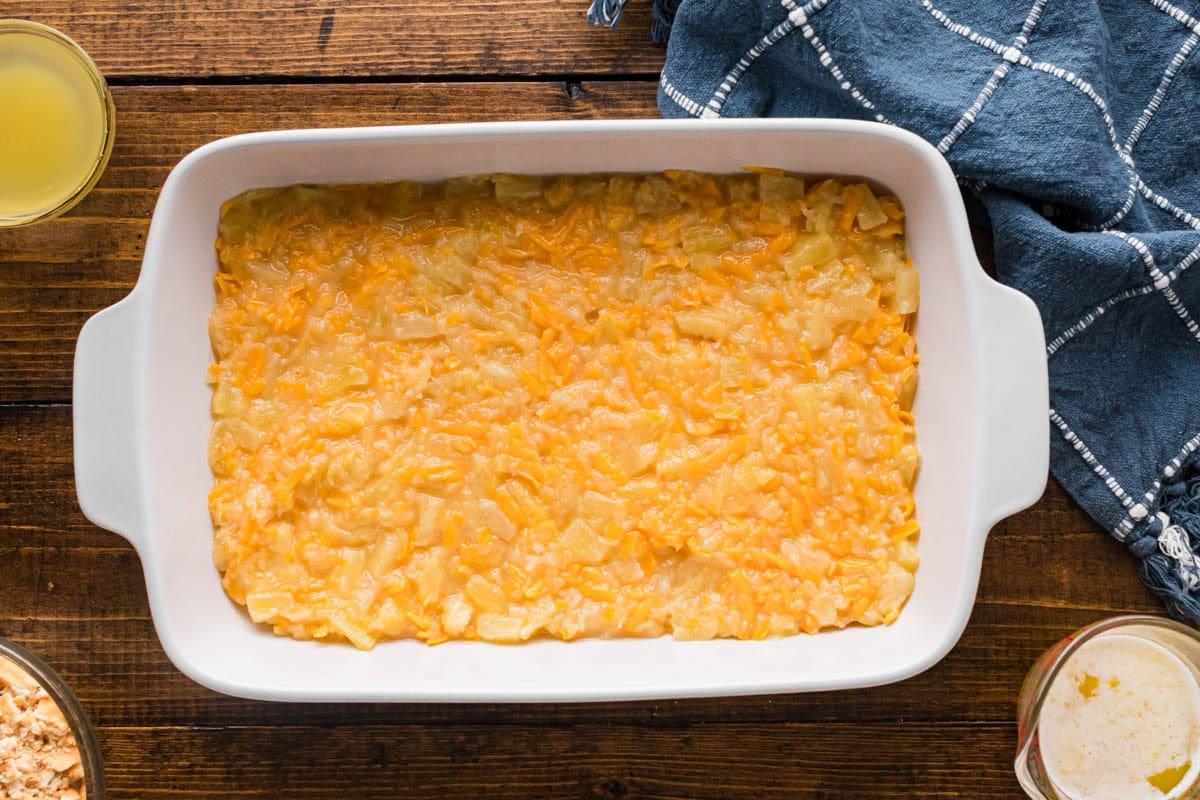 Pineapple cheese mixture covering the bottom on a casserole dish.