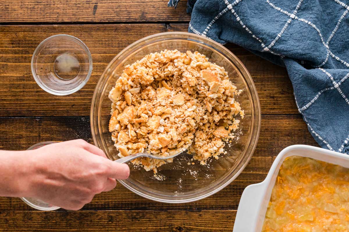Crushed ritz cracker, butter and pineapple juice combined in a bowl to make topping for casserole.
