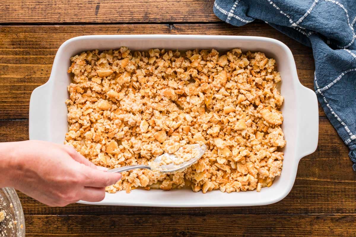 Cracker topping placed on top of pineapple cheese mixture in casserole dish.