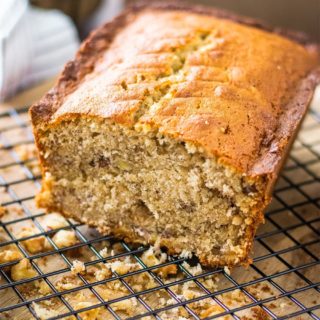 A half loaf of banana bread on a cooling rack.