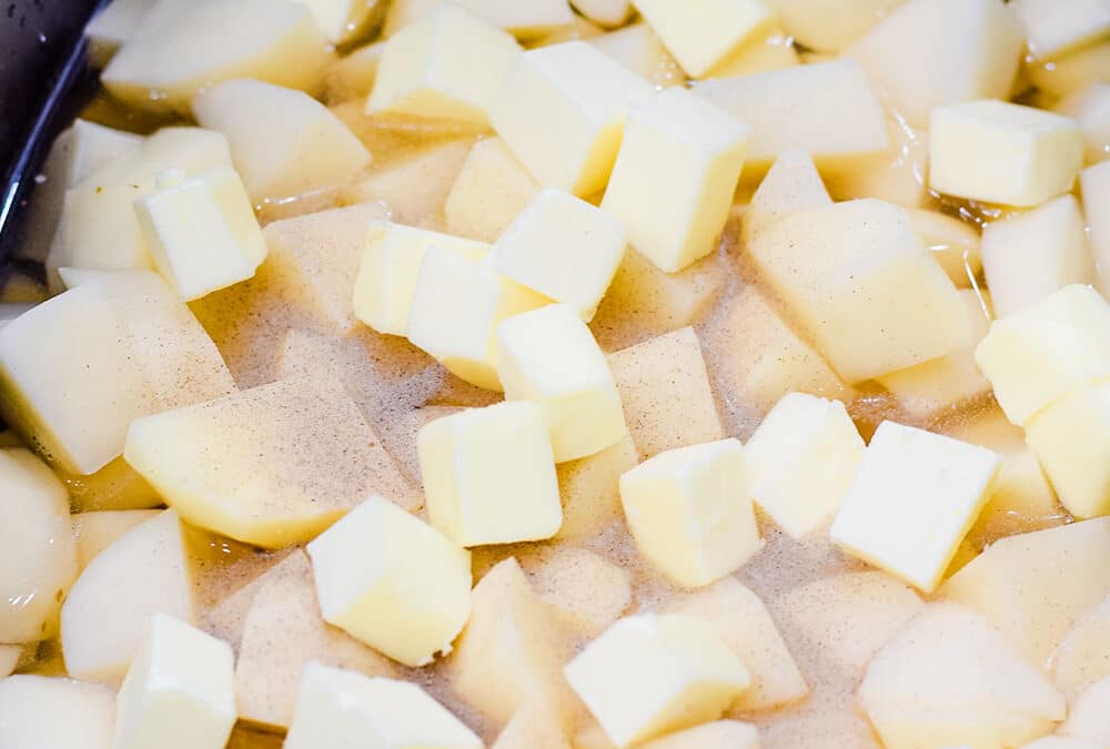 Cubed potatoes with spices in a crock pot.