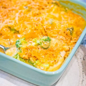 A light blue casserole dish is filled with this Broccoli Cheddar Chicken Casserole recipe