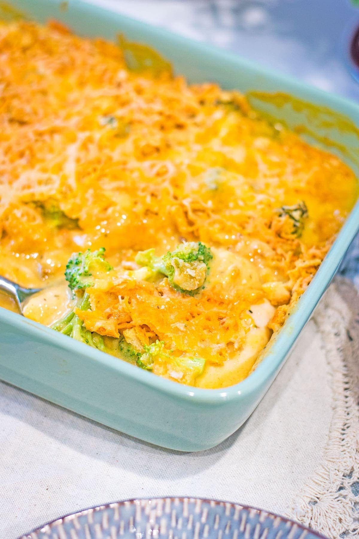 A light blue casserole dish is filled with this Broccoli Cheddar Chicken Casserole recipe