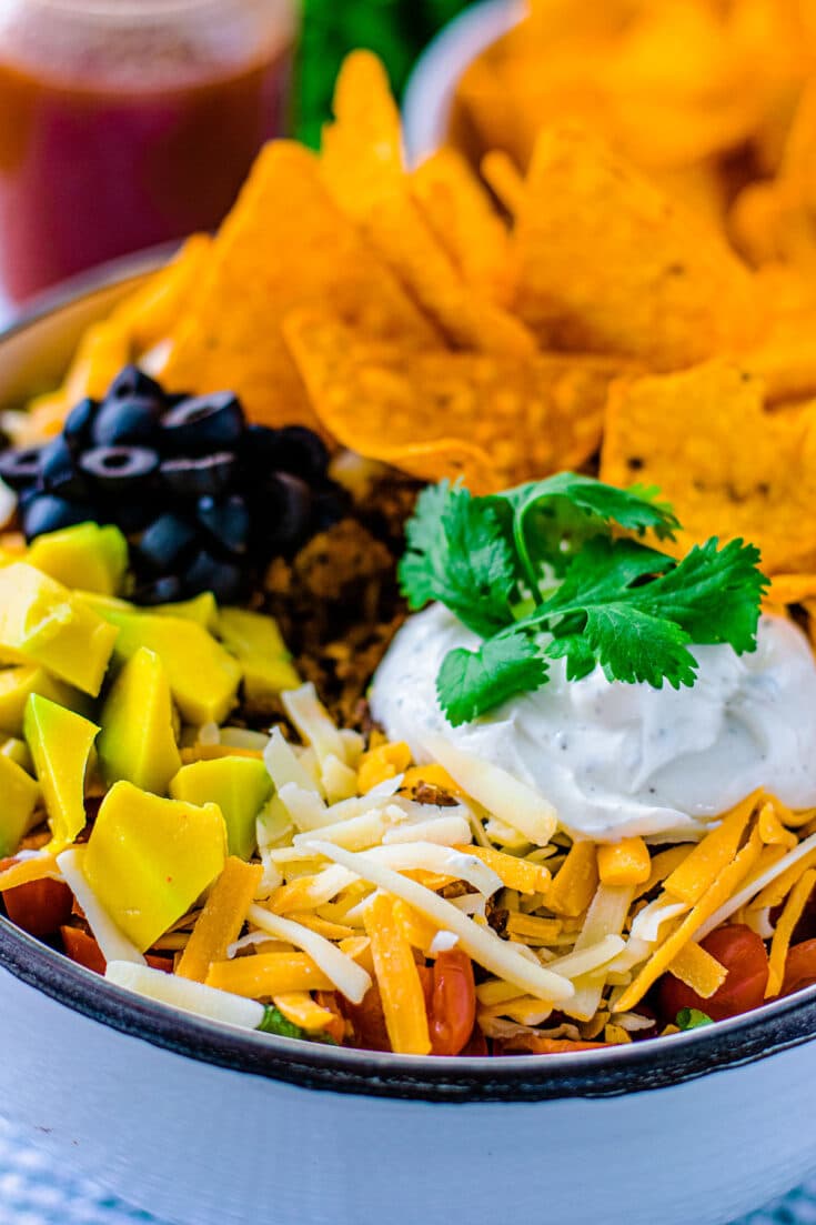 tossed green salad with seasoned ground beef, beens, cheese, lettuce, crumbled nacho chips combined to create a Dorito Taco Salad Recipe