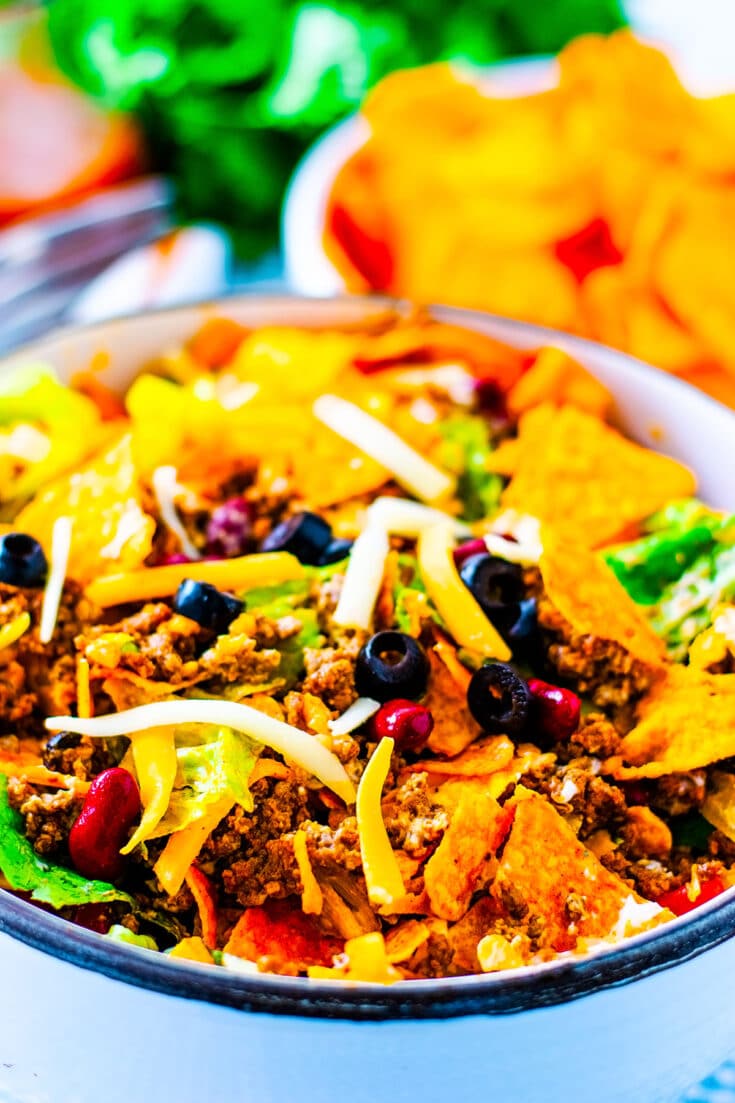 tossed green salad with seasoned ground beef, beens, cheese, lettuce, crumbled nacho chips combined to create a Dorito Taco Salad Recipe