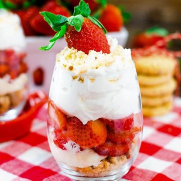 Strawberry Parfait in a clear dessert glass topped with whipped cream and a whole strawberry.