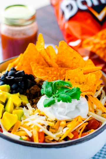 tossed green salad with seasoned ground beef, beens, cheese, lettuce, crumbled nacho chips combined to create a Dorito Taco Salad Recipe