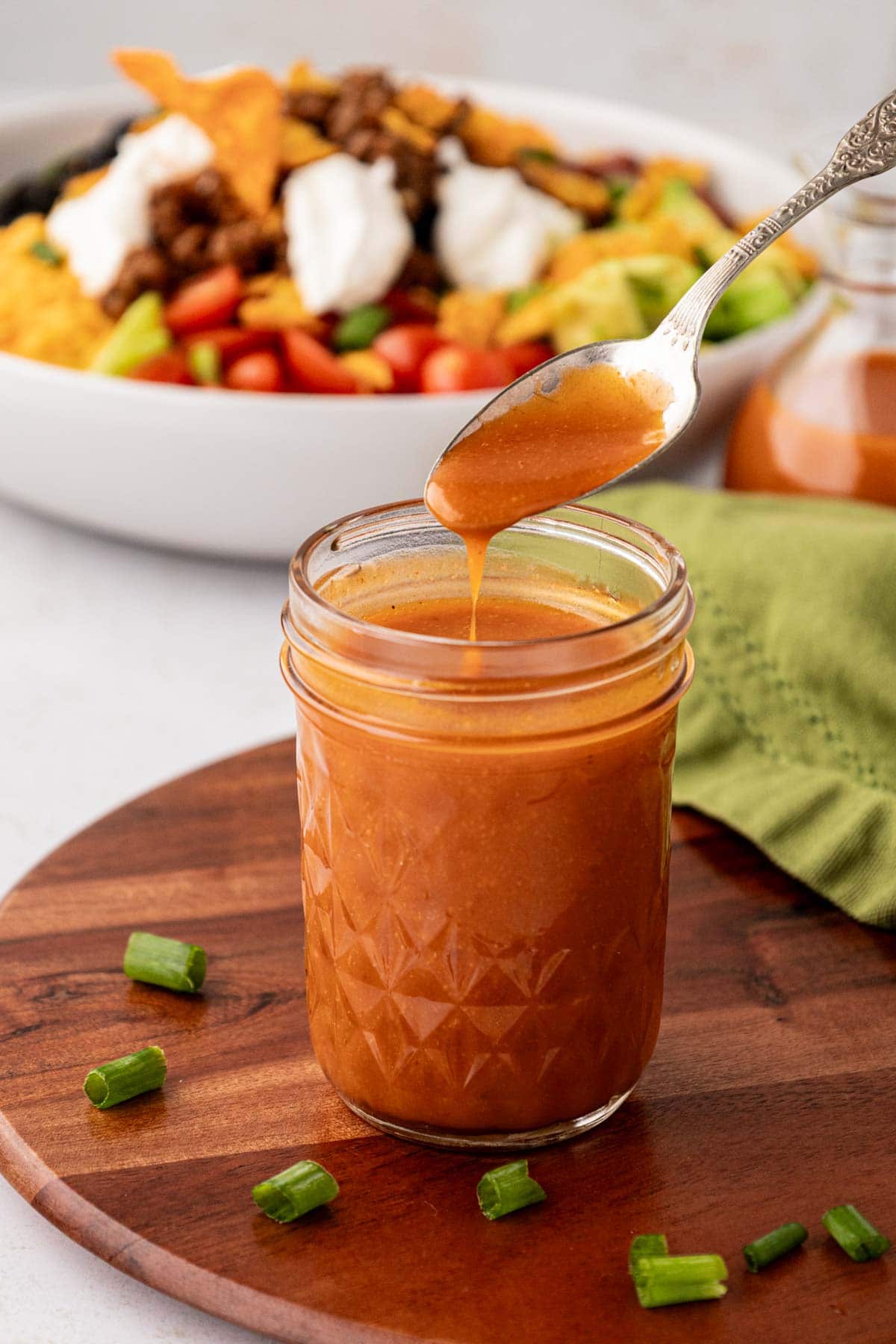 Removing a spoonful of Catalina dressing from a mason jar.