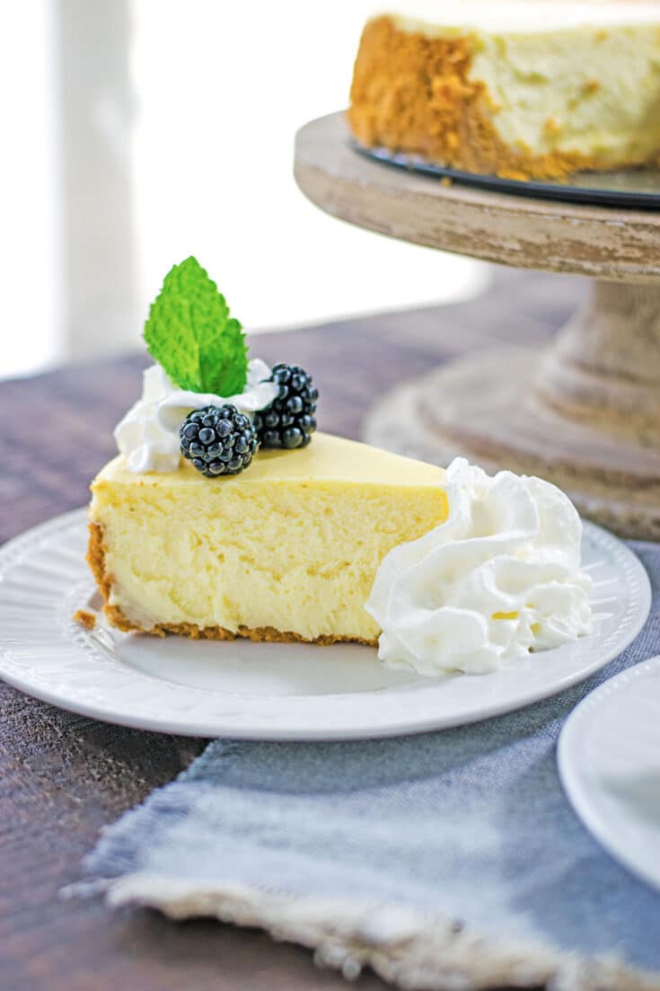 Classic Cheesecake Recipe - sliced with blackberries and whipped cream.