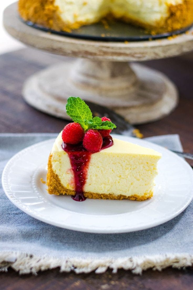 Classic Cheesecake Recipe - sliced with raspberry sauce.